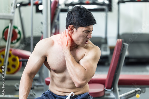 Asian man have injury muscle in a neck pain after workout in gym,Healthcare concept