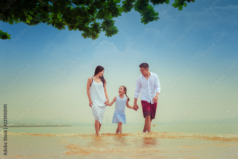 Happy asian family - father, mother, kid hold hands and run together with fun along daylight sea beach. Travel, active lifestyle, parents with children on tropical summer vacations..