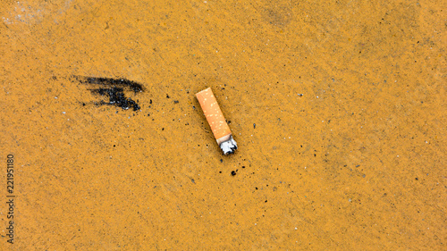 cigarette stub on dirty yellow floor photo