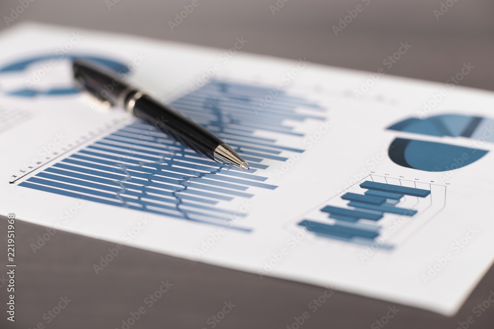 business background.a pen and a sheet with a financial report on the table - obrazy, fototapety, plakaty 