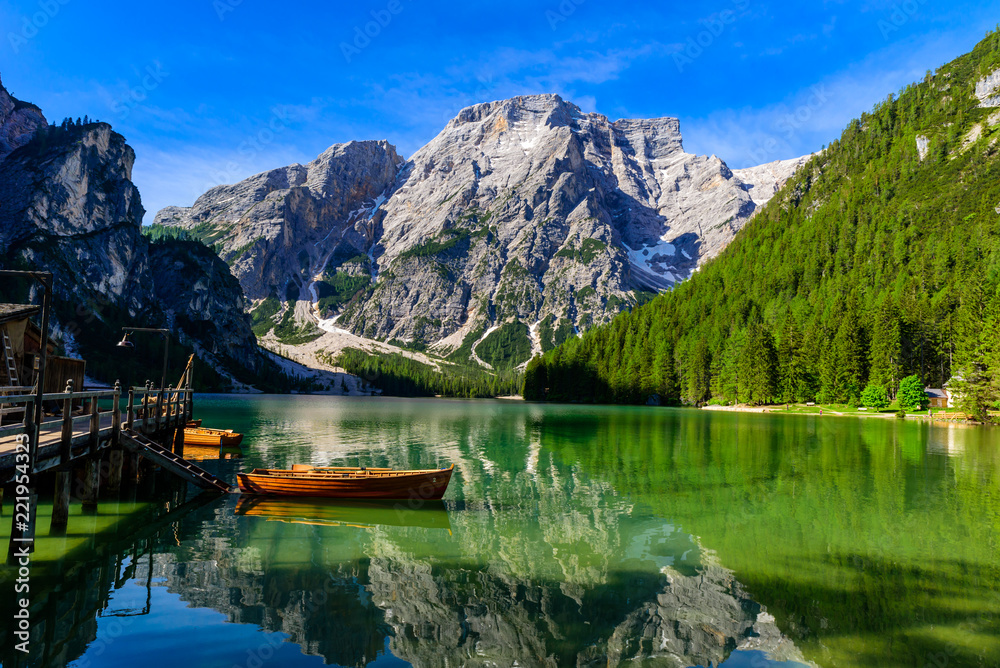 Naklejka premium Lake Braies (also known as Pragser Wildsee or Lago di Braies) in Dolomites Mountains, Sudtirol, Italy. Romantic place with typical wooden boats on the alpine lake. Hiking travel and adventure.