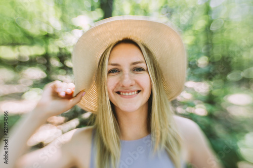 portrait of young woman with hat in the woods