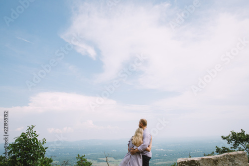 young couple standing in the mountains with a fantastic view