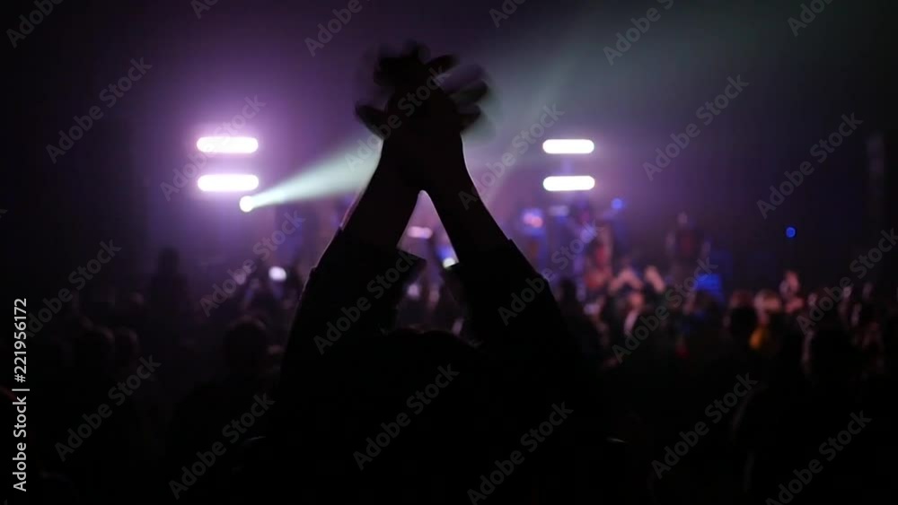 Fan spectator clapping hands up in air enjoying music concert light lumiere