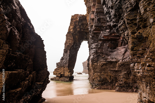 Natural rock arches on Cathedrals beach in low tide photo