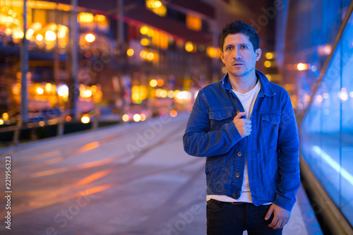 Hispanic man exploring the city streets at night