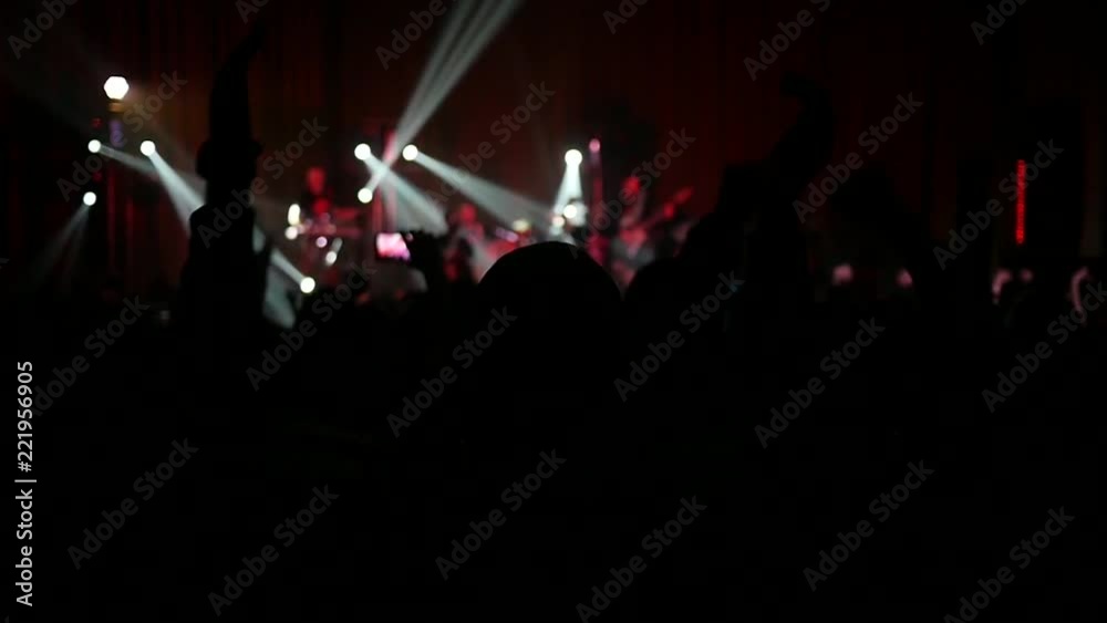 Crowd fan spectators silhouettes sway hands up in air at concert flash light lumiere