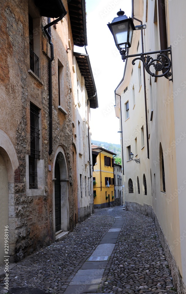 Obraz premium Medieval halley with stone floor and old iron street lamp. Brescia, Italy.