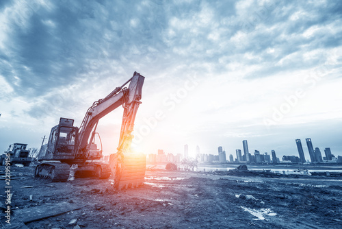 excavator in construction site on sunset sky background