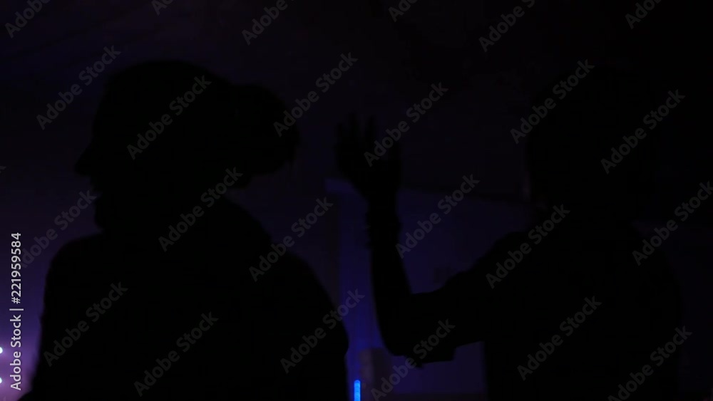 Spectator fan girl silhouette dance and jump at a concert flash light lumiere