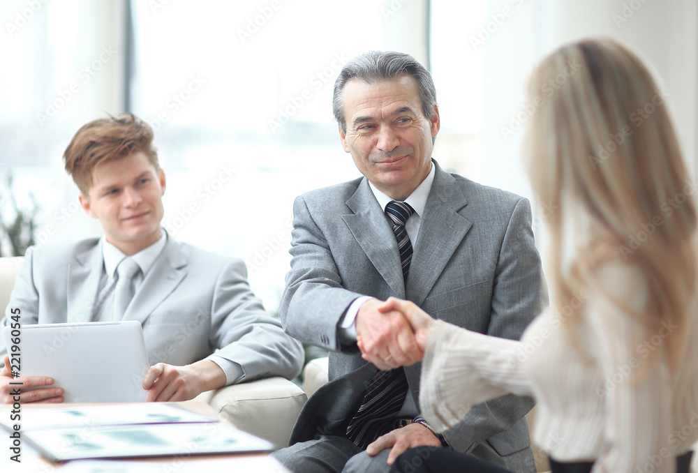 handshake of a businessman and the business woman behind a Desk handshake of a businessman and the business woman behind a Desk