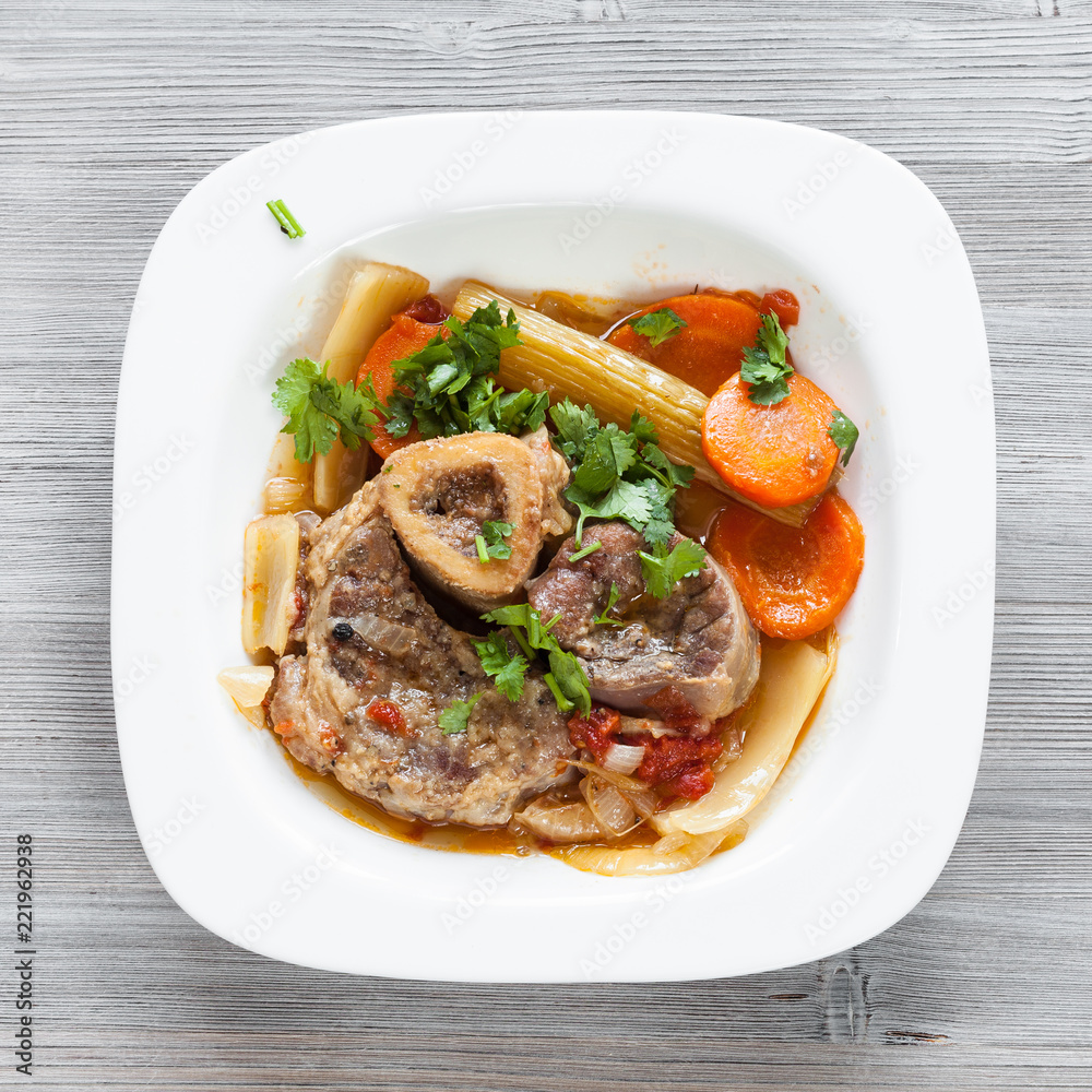 top view of italian dish Ossobuco on gray board top view of italian dish Ossobuco on gray board