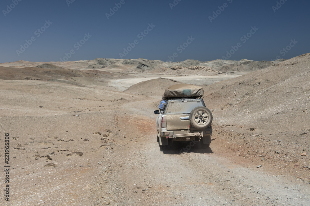 ein Geländewagen fährt durch ein Mondlandschaft, Namibia