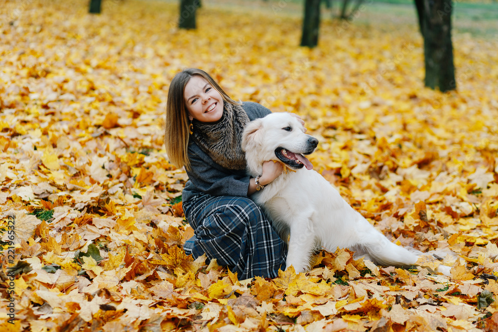 woman hugging her dog in the park in autumn woman hugging her dog in the park in autumn