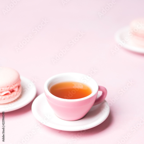 Still life with french delicious dessert macaroons and cup of coffee on pink background with copy space