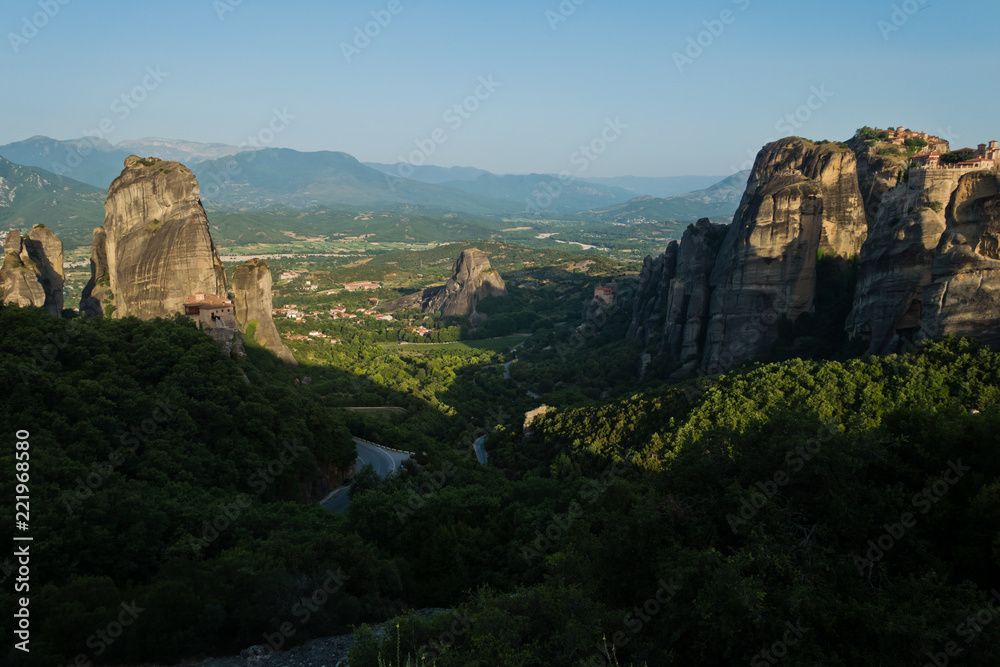 Huge rocks with christian orthodox monasteries at sunrise with Meteora valley in background near Kalambaka, Thessaly, Greece Huge rocks with christian orthodox monasteries at sunrise with Meteora valley in background near Kalambaka, Thessaly, Greece