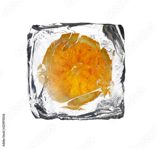 frozen orange slice inside a ice cube isolated on white