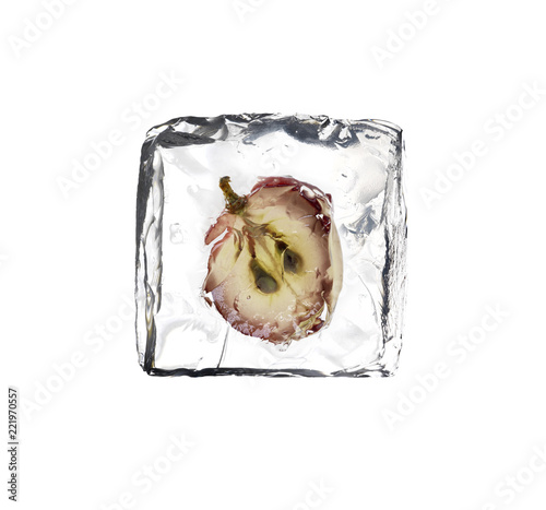 frozen red grape slice inside a ice cube isolated on white