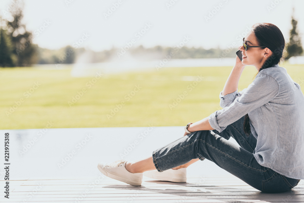 selective focus of happy woman in sunglasses talking on smartphone outdoors selective focus of happy woman in sunglasses talking on smartphone outdoors