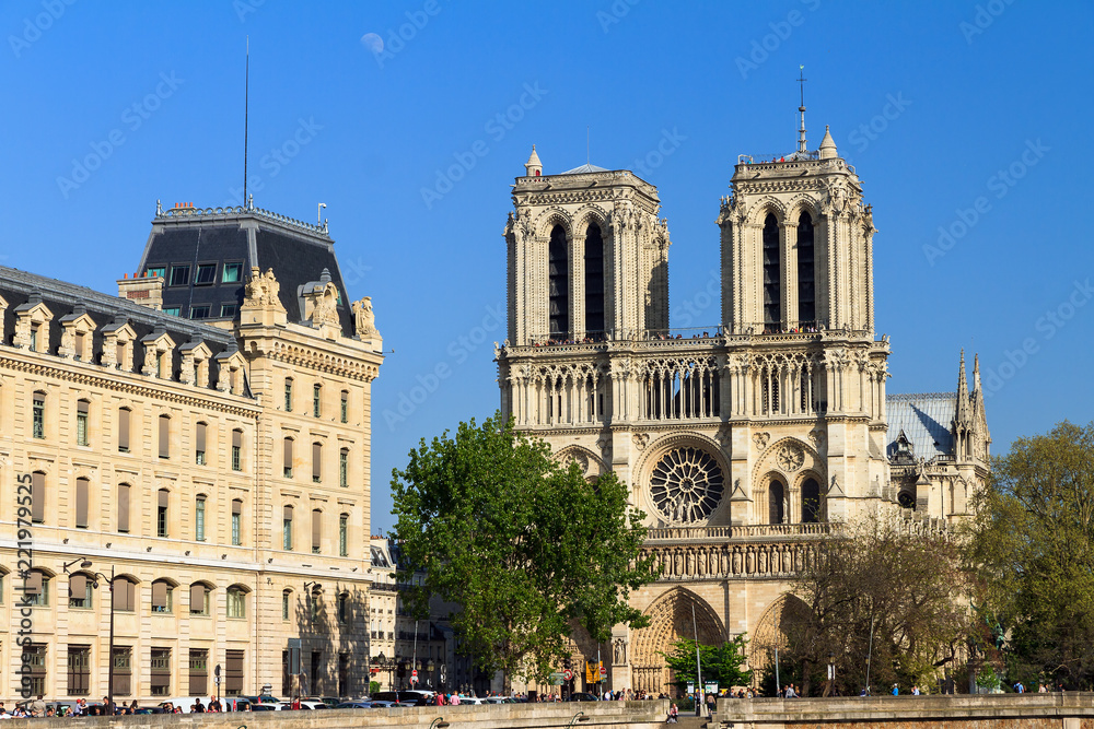 Beautiful view of the Notre-Dame Cathedral with a faint moon above it in Paris 