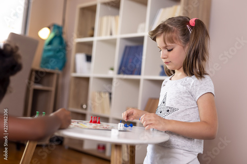 Little girls playing ludo board game