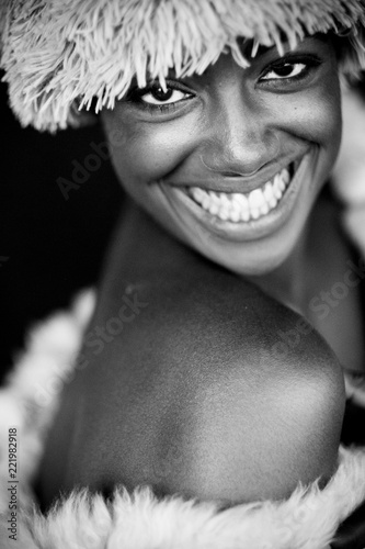 fine art black and white beautiful portrait of young and cheerful model smiling at the camera. happiness and model posing in front of the camera looking at you. beauty african diverstity concept photo