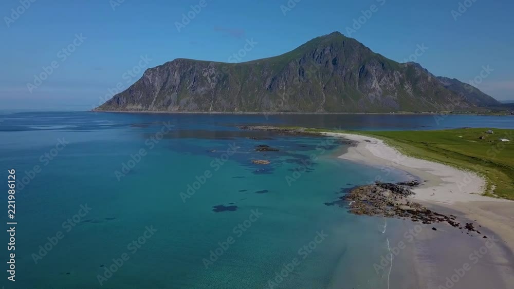 Flying over the sandy beach. The beautiful coast of Lofoten. Clear water and a mountain on the horizon. Norway Flying over the sandy beach. The beautiful coast of Lofoten. Clear water and a mountain on the horizon. Norway