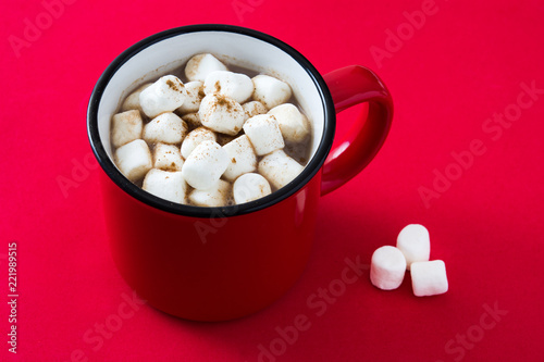 Christmas cocoa with marshmallow in mug on red background. 
