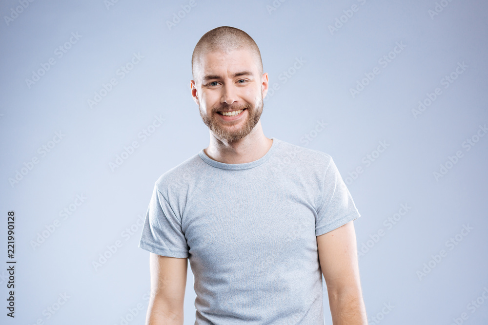 Great mood. Delighted cheerful man smiling to you while standing against blue background Great mood. Delighted cheerful man smiling to you while standing against blue background