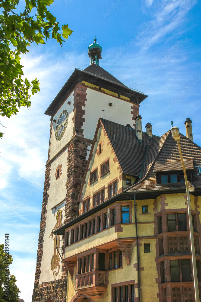 View on the ancient buildings with the Schwabentor clock tower in Freiburg im Breisgau, Germany on a sunny day.
