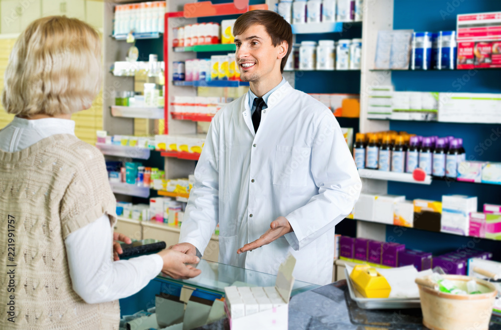 Friendly smiling pharmacist counseling female customer
