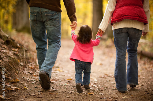 Young Family Walking in Autumn Woods
