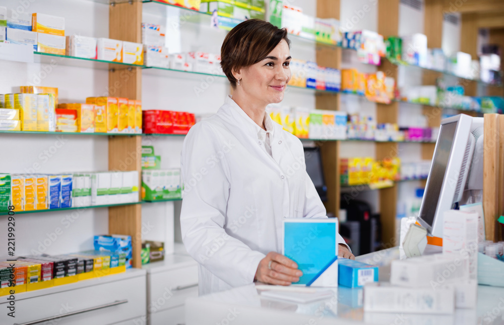 Female pharmacist offering help in choosing at counter in pharmacy