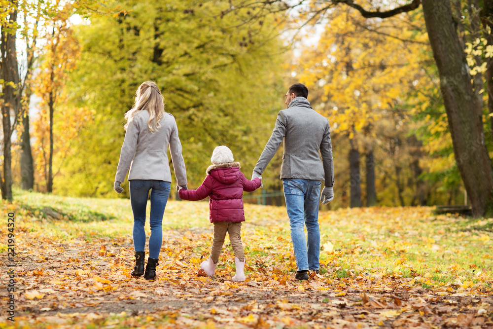 Obraz premium family, season and people concept - happy mother, father and little daughter walking at autumn park