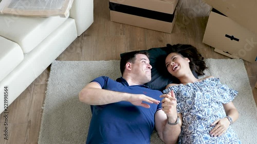 Couple resting on the floor of their new home. Top view footage