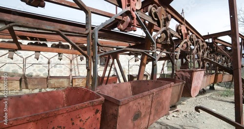 Second station of old Cable Car Chilecito-La Mejicana mine. Detail of rusty iron wagons. Camera moves sideways slowly linear disposition of wagons. National industrial heritage photo