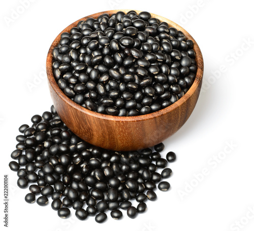 uncooked black bean in the wooen bowl, isolated on white