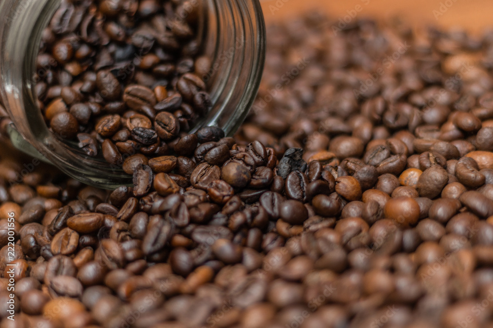 Coffee beans, poured from a glass transparent jar. Coffee beans, poured from a glass transparent jar.