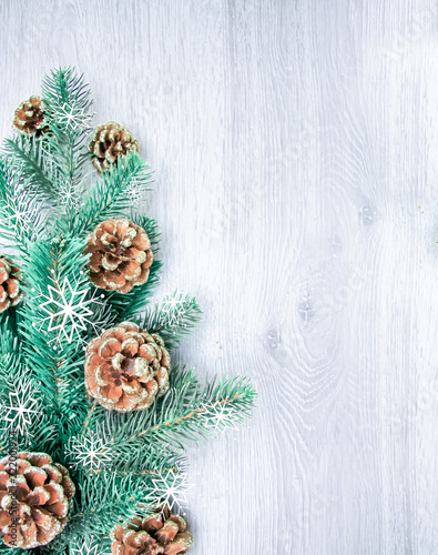 Christmas and New Year's composition. The pine cones, spruce branches on a wooden white background, top view