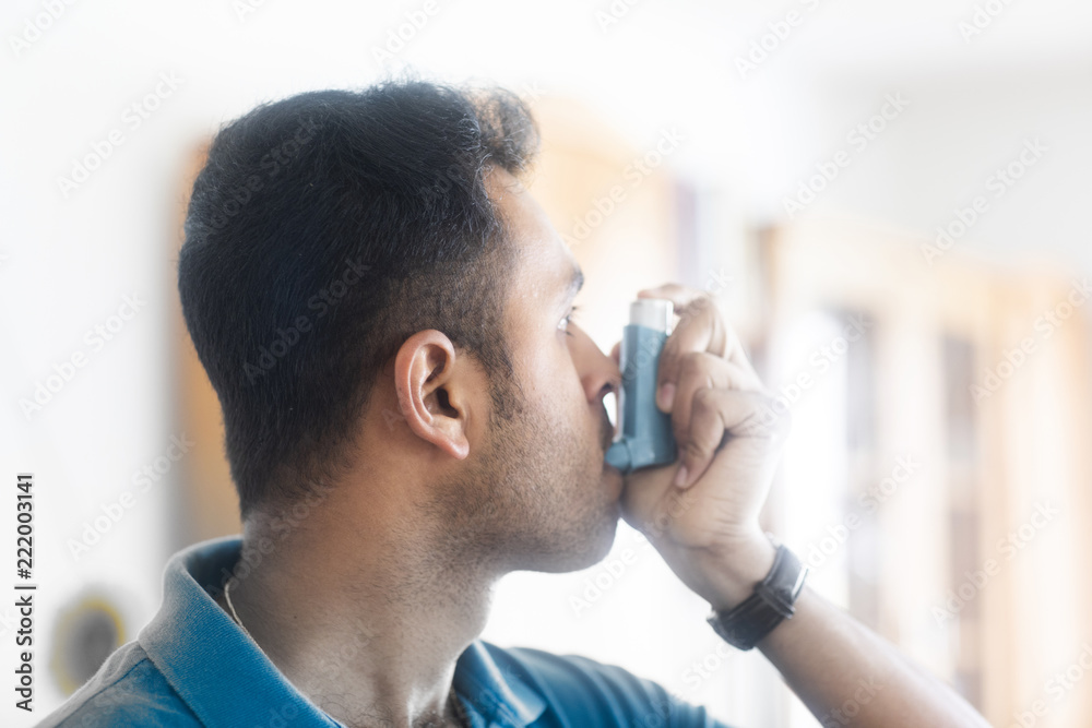 Junger Mann inhaliert Spray für die Lunge Junger Mann inhaliert Spray für die Lunge