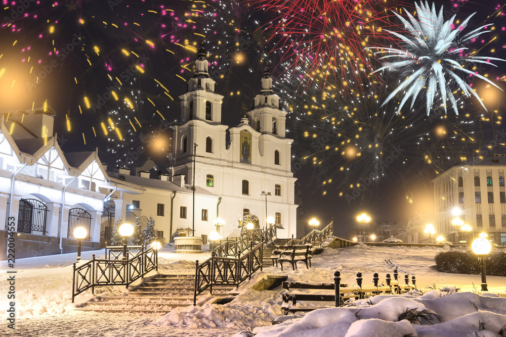 Festive salute in night Minsk for Christmas and New Year. Celebrating New Year in Belarus. Fireworks and salutes, night lights of city on main Orthodox church of holy spirit in center of city.
