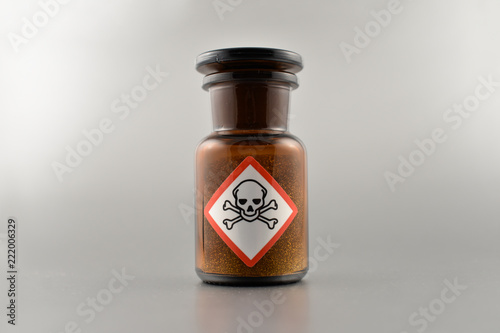 Vial with poison stock images. Vial with warning pictogram stock images. Laboratory accessories. Vials on a silver background. Brown glass containers. Brown chemical glass