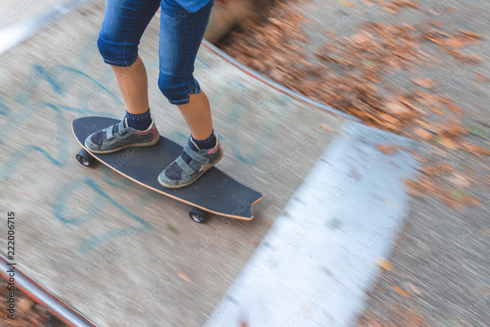 Ein Kind skatet auf einem Longboard eine Rampe herauf, Detailaufnahme Ein Kind skatet auf einem Longboard eine Rampe herauf, Detailaufnahme