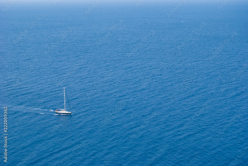 Sailing boat going motorized in the middle of the blue