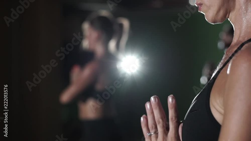 Group of women practice namaste yoga hot in studio rapid slow motion