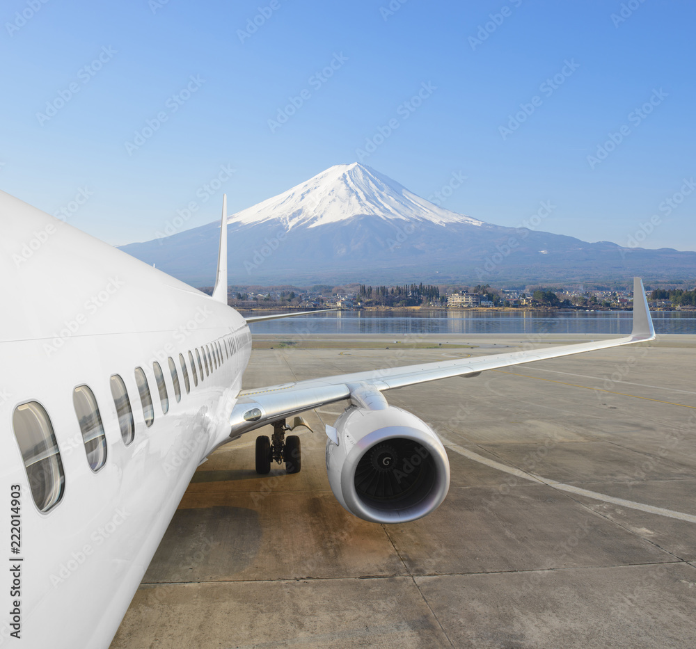 Fototapeta premium Commercial airplane parked at the airport with Mt.Fuji in winter background