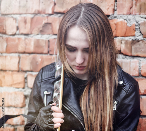 Beautiful young girl rocker with electric guitar. A rock musicia photo