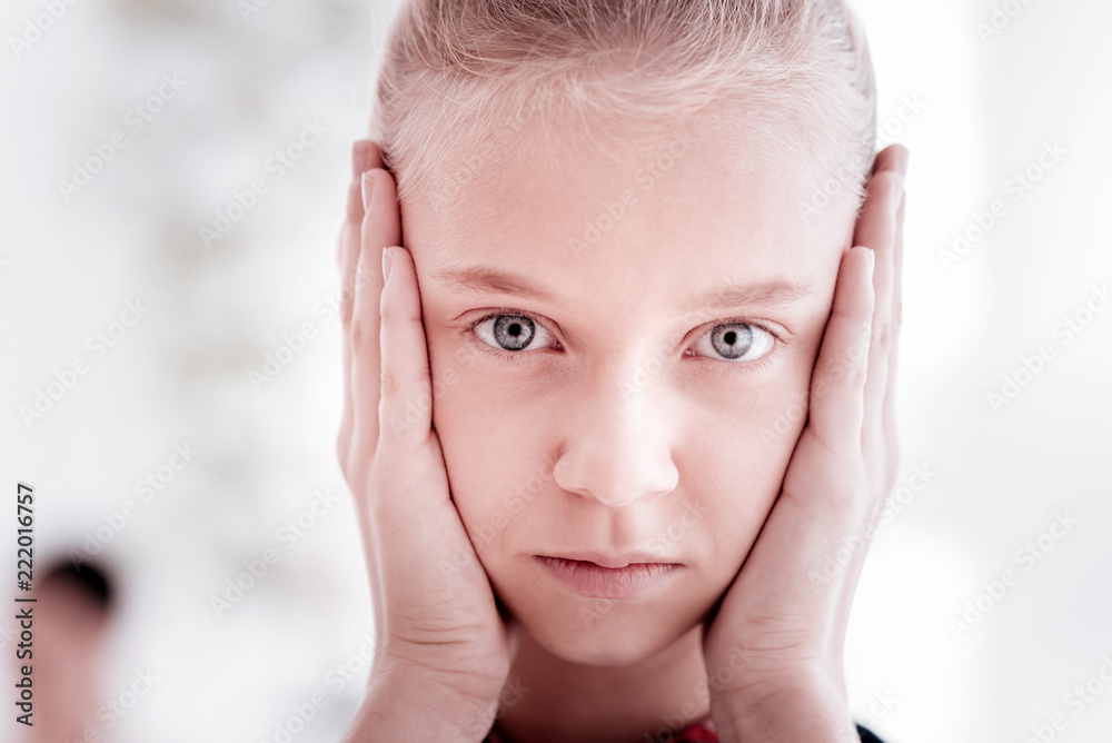Oh no. Young serious teenage girl putting her hands to her face and looking thoughtful and unhappy Oh no. Young serious teenage girl putting her hands to her face and looking thoughtful and unhappy