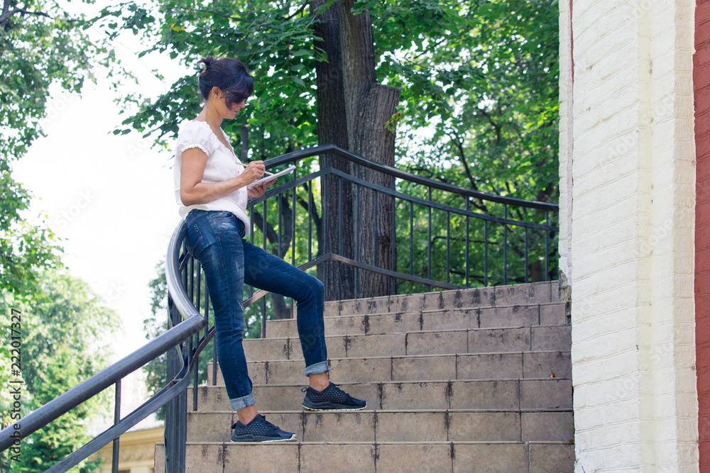 A brunette woman in stands on the steps A brunette woman in stands on the steps