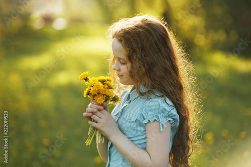 Little girl with bouquet of yellow dandelions.
